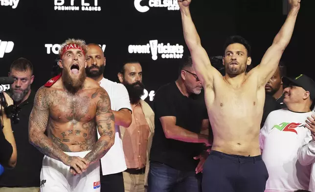 FILE - Jake Paul, front left, and Julio Cesar Chavez Jr., front right, pose for photographers following a ceremonial weigh-in ahead of their cruiserweight boxing match, in Anaheim, Calif., June 27, 2025. (AP Photo/Chris Pizzello, File)