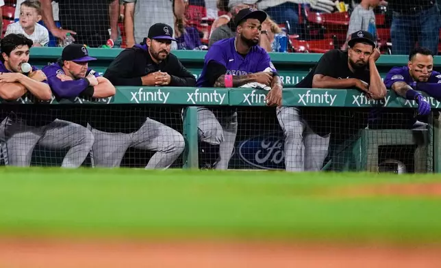 FILE - The Colorado Rockies rest on the dugout rail while trailing the Boston Red Sox in the ninth inning of a baseball game at Fenway Park, Tuesday, July 8, 2025, in Boston. (AP Photo/Charles Krupa, File)