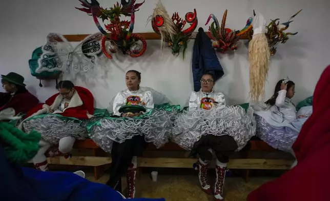 Diablada dancers rest after performing in a celebration of the Virgen de Carmen or Our Lady of Mount Carmel, Chile's patron saint, in La Tirana, Chile, Tuesday, July 15, 2025. (AP Photo/Esteban Felix)