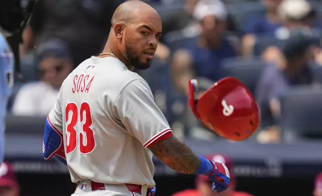 Philadelphia Phillies' Edmundo Sosa (33) throws a helmet after striking out during the fifth inning of a baseball game against the New York Yankees, Saturday, July 26, 2025, in New York. (AP Photo/Yuki Iwamura)