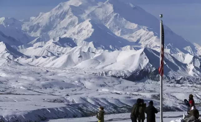FILE - People stand at the Eielson Visitor Center with a view of North America's tallest peak, Denali, in the background, Sept. 2, 2015, in Denali National Park and Preserve, Alaska. (AP Photo/Becky Bohrer, File)