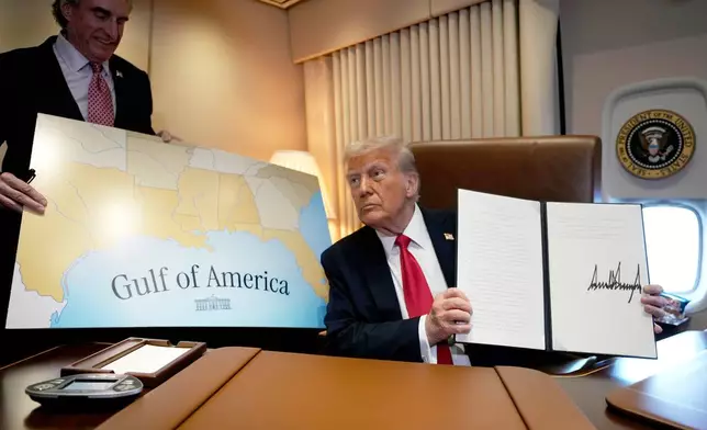FILE - President Donald Trump holds up a signed proclamation declaring Feb. 9 Gulf of America Day, as Interior Secretary Doug Burgum watches aboard Air Force One as Trump travels from West Palm Beach, Fla. to New Orleans, Feb. 9, 2025. (AP Photo/Ben Curtis, File)