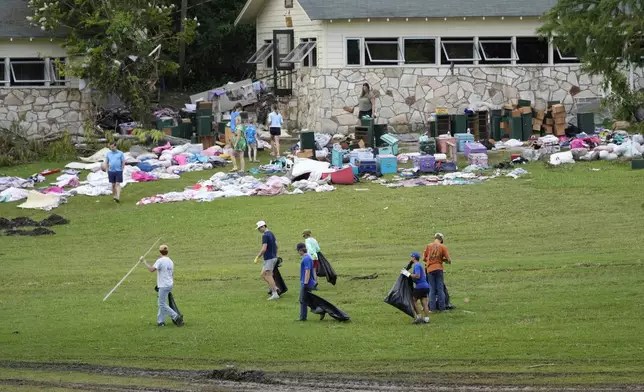 People come to pick up items as the others clean up the site after the flood at Camp Mystic in Hunt, Texas on Wednesday, July 9, 2025. (AP Photo/Ashley Landis)