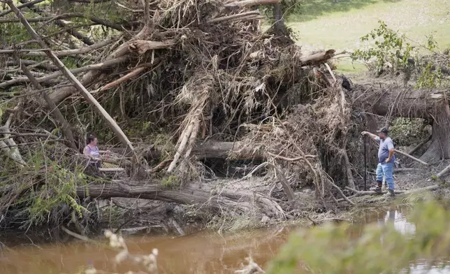 People search along the Guadalupe River after flooding in Kerrville, Texas on Wednesday , July 9, 2025. (AP Photo/Gerald Herbert)