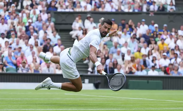 Novak Djokovic of Serbia dives to return to Miomir Kecmanovic of Serbia during a third round men's singles match at the Wimbledon Tennis Championships in London, Saturday, July 5, 2025. (AP Photo/Kirsty Wigglesworth)
