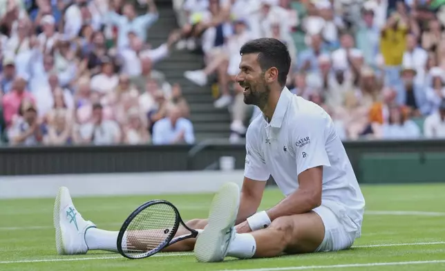 Novak Djokovic of Serbia sits on the grass after diving to return to Miomir Kecmanovic of Serbia during a third round men's singles match at the Wimbledon Tennis Championships in London, Saturday, July 5, 2025. (AP Photo/Kirsty Wigglesworth)