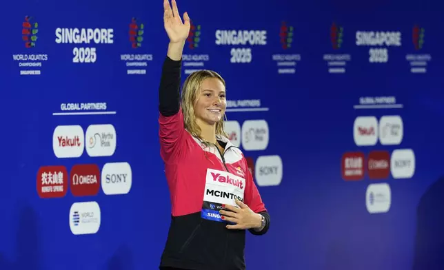 Gold medalist Summer McIntosh of Canada celebrates on the podium after the women's 200-meter individual medley final at the World Aquatics Championships in Singapore, Monday, July 28, 2025. (AP Photo/Vincent Thian)