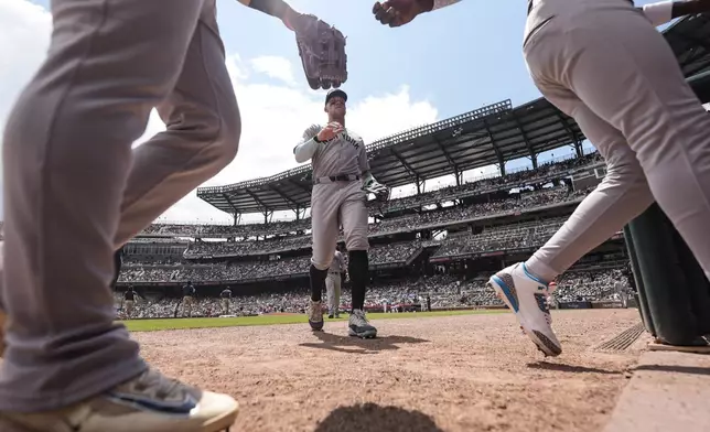 New York Yankees outfielder Aaron Judge, center, walks with his team back to the dugout in the sixth inning of a baseball game against the Atlanta Braves, Sunday, July 20, 2025, in Atlanta. (AP Photo/Mike Stewart)