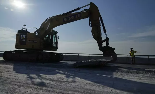 A demolition crew removes a slab of concrete from the remaining portions of the Francis Scott Key Bridge, Wednesday, July 30, 2025, in Baltimore. (AP Photo/Stephanie Scarbrough)