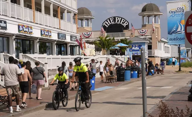 Community Service Officers from the Old Orchard Beach Police Dept. patrol on bicycles, Tuesday, July 29, 2025, in Old Orchard Beach, Maine. (AP Photo/Robert F. Bukaty)