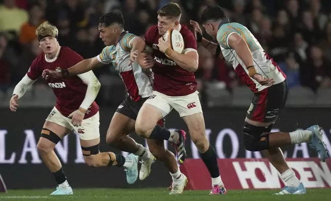 Garry Ringrose of the British &amp; Irish Lions, second right, attempts to get past First Nations &amp; Pacifika XV's Kalani Thomas, second left, during their rugby union match in Melbourne, Australia, Tuesday, July 22, 2025. (AP Photo/Asanka Brendon Ratnayake)