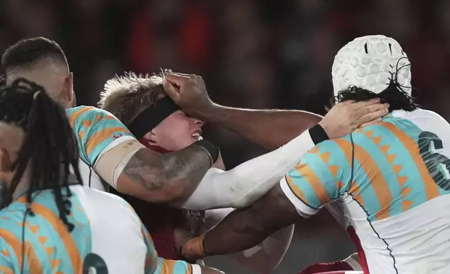 Henry Pollock of the British &amp; Irish Lions, center, is pushed in the head by First Nations &amp; Pacifika XV's Seru Uru during their rugby union match in Melbourne, Australia, Tuesday, July 22, 2025. (AP Photo/Asanka Brendon Ratnayake)