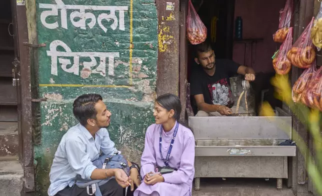 A couple talks sitting outside a tea shop at Basantapur Durbar square in Kathmandu, Nepal, Wednesday, July 23, 2025. (AP Photo/Niranjan Shrestha)