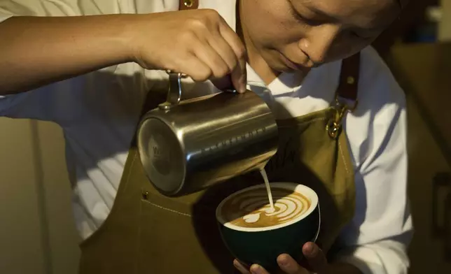An employees pours coffee for a customer at Himalayan Java cafe at Boudhanath Stupa in Kathmandu, Nepal, Tuesday, June 10, 2025. (AP Photo/Niranjan Shrestha)