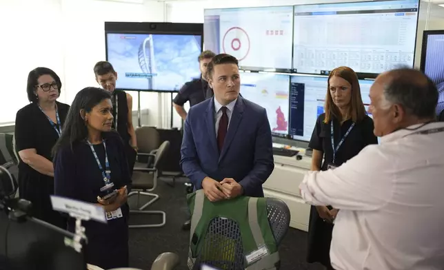Britain's Health Secretary Wes Streeting, center, listens during a visit to NHS National Operations Centre to see how they manage industrial action, in London, Friday, July 25, 2025. (Jordan Pettitt/PA via AP)