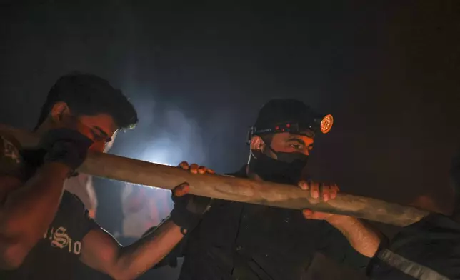 Emergency responders with the Syrian Civil Defense, known as the White Helmets, work to extinguish a wildfire near the town of Rabia, in Syria's Latakia countryside, early Monday, July 7, 2025. (AP Photo/Ghaith Alsayed)