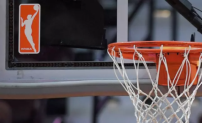 FILE - The WNBA logo is seen near a hoop before an WNBA basketball game at Mohegan Sun Arena, Tuesday, May 14, 2019, in Uncasville, Conn. (AP Photo/Jessica Hill, File)
