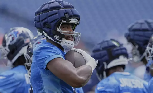 Tennessee Titans wide receiver Treylon Burks (16) runs with the ball during "Back Together Weekend" at the team's NFL football training camp Saturday, July 26, 2025, in Nashville, Tenn. (AP Photo/George Walker IV)