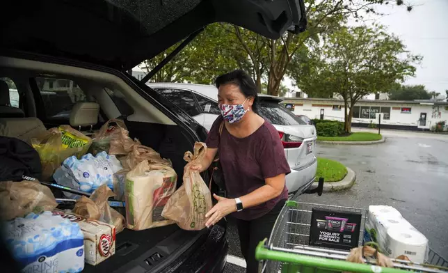 FILE - Leslie Crowell loads water, paper towels and other groceries into her car Wednesday, Nov. 11, 2020 at Publix in preparation for Tropical Storm Eta in Tampa, Fla. (Martha Asencio Rhine/Tampa Bay Times via AP,File)