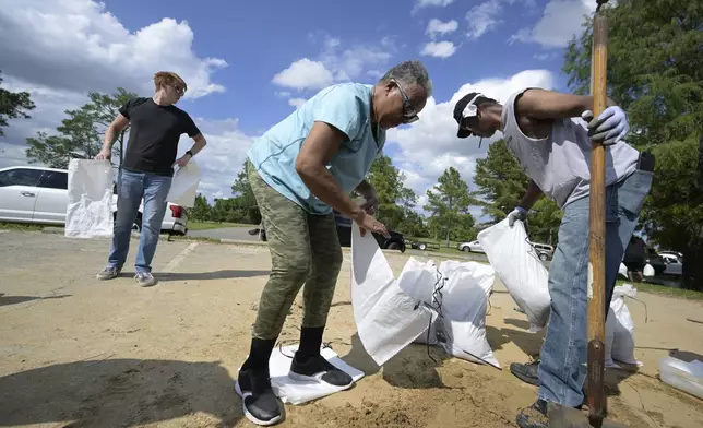 FILE - Johnny Ford, right, and his wife Jerria Ford fill free sand bags at an Orange County park in preparation for the arrival of Hurricane Ian, Monday, Sept. 26, 2022, in Orlando, Fla. (AP Photo/Phelan M. Ebenhack,File)