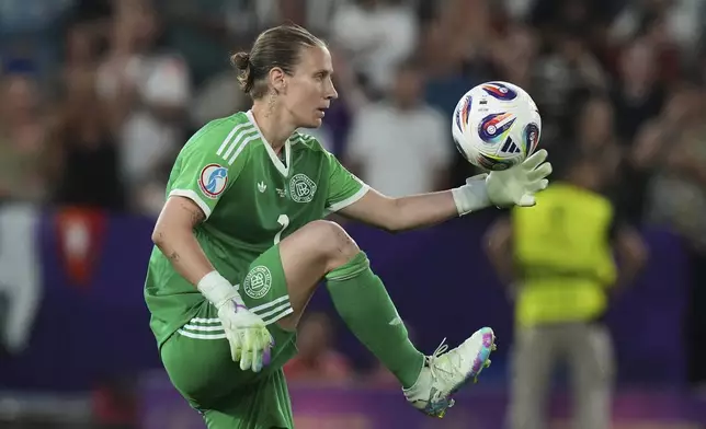 Germany goalkeeper Ann-Katrin Berger picks up the ball after scoring her penalty during a penalty shootout at the end of the Women's Euro 2025 quarterfinals soccer match between France and Germany at St. Jakob-Park in Basel, Switzerland, Saturday, July 19, 2025. (AP Photo/Alessandra Tarantino)