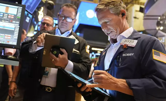 Robert Charmak, right, works on the floor at the New York Stock Exchange in New York, Wednesday, July 30, 2025. (AP Photo/Seth Wenig)