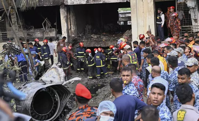 Firemen look for the survivors after a Bangladesh Air Force training aircraft that crashed onto a school campus shortly after takeoff in Dhaka, Bangladesh, Monday, July 21, 2025. (AP Photo/Mahmud Hossain Opu)