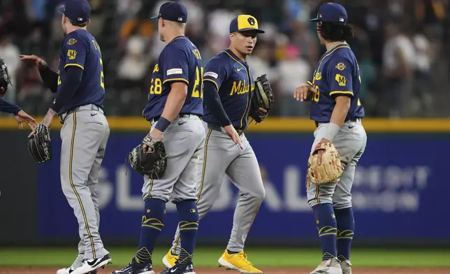 The Milwaukee Brewers, including left fielder Isaac Collins, second from right, and third baseman Anthony Seigler, right, celebrate a win over the Seattle Mariners in a baseball game Monday, July 21, 2025, in Seattle. (AP Photo/Lindsey Wasson)