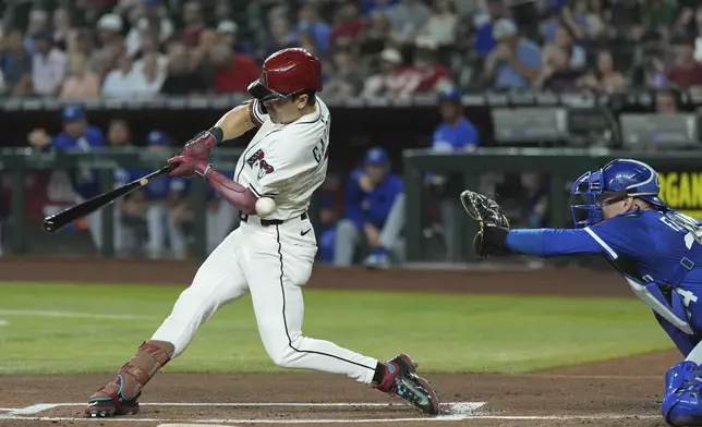 Arizona Diamondbacks' Corbin Carroll, left, strikes out as Kansas City Royals catcher Freddy Fermin reaches for the ball during the first inning of a baseball game Sunday, July 6, 2025, in Phoenix. (AP Photo/Ross D. Franklin)