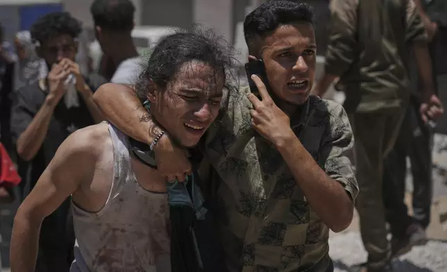 Palestinians react after carrying the bodies of those killed while trying to reach aid trucks entering northern Gaza through the Zikim crossing with Israel, at Shifa Hospital in Gaza City, Sunday, July 20, 2025. (AP Photo/Jehad Alshrafi)