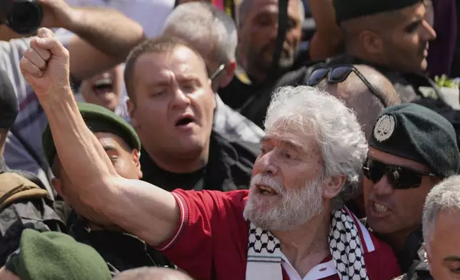 Lebanese pro-Palestinian militant Georges Abdallah, second right, who was serving a life sentence for complicity in the 1982 murders of an American and an Israeli diplomat in Paris, raises his fist and chants among supporters upon his arrival at Beirut's Rafik Hariri International Airport in Beirut, Lebanon, Friday, July 25, 2025. (AP Photo/Hussein Malla)