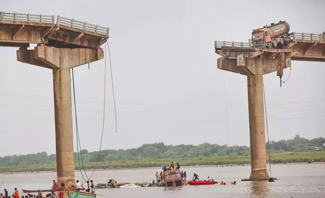 Rescuers and locals look for survivors after several vehicles fell into a river following the collapse of a portion of a bridge in Mujpur near Vadodara in the Indian state of Gujarat, Wednesday, July 9, 2025. (AP Photo)