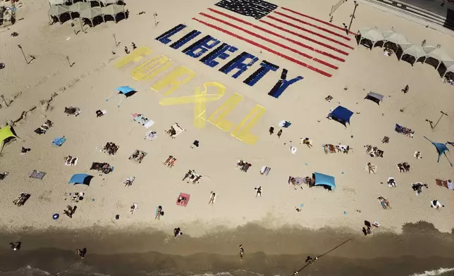 An installation with the U.S. flag and the message "liberty for all," which was created by relatives and supporters of Israelis held captive in the Gaza Strip, calls for their release and urges a ceasefire on the beach in Tel Aviv, Israel, on Friday, July 4, 2025. (AP Photo/Oded Balilty)