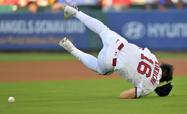 Los Angeles Angels starting pitcher Yusei Kikuchi loses his glove and flips over as he tries to field a single by Texas Rangers' Sam Haggerty during the first inning of a baseball game Monday, July 7, 2025, in Anaheim, Calif. (AP Photo/Jayne Kamin-Oncea)