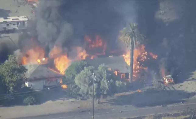 In this aerial image taken from video, smoke and flames rise from a fireworks warehouse explosion, July 1, 2025, Esparto, Calif. (KGO via AP)