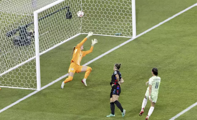 Italy's Barbara Bonansea, right, scores the opening goal past England's goalkeeper Hannah Hampton during the Women's Euro 2025 semifinals soccer match between England and Italy at Stade de Geneve in Geneva, Switzerland, Tuesday, July 22, 2025. (Salvatore Di Nolfi/Keystone via AP)