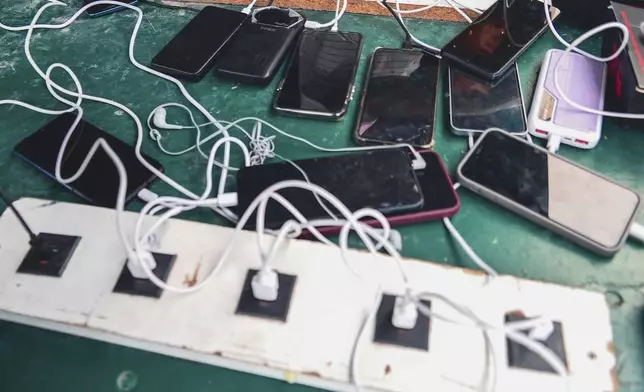 Phones are kept for charging at a Doctors Without Borders informal camp in Mardyck, northern France, Wednesday, July 2, 2025. (AP Photo/Nicolas Garriga)