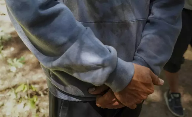 Qassim, 26, a Palestinian, wears a hoodie stained with what he said is his wife Anouar's blood, in the Ecault forest northern France, Thursday, July 3, 2025. (AP Photo/Nicolas Garriga)