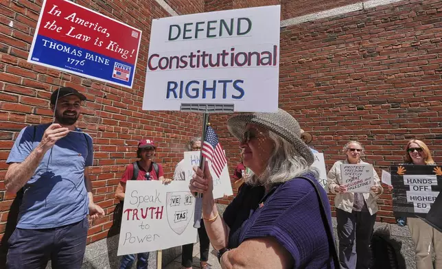 Protestors gather outside the Moakley Federal Courthouse, where Harvard University appeared to challenge $2.6 billion in funding cuts by the Trump administration, Monday, July 21, 2025, in Boston. (AP Photo/Charles Krupa)
