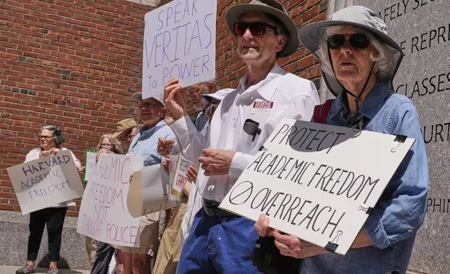 Protestors gather outside the Moakley Federal Courthouse, where Harvard University appeared to challenge $2.6 billion in funding cuts by the Trump administration, Monday, July 21, 2025, in Boston. (AP Photo/Charles Krupa)