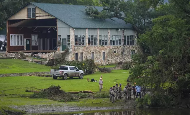 Officials search on the grounds of Camp Mystic along the banks of the Guadalupe River after a flash flood swept through the area Sunday, July 6, 2025, in Hunt, Texas. (AP Photo/Julio Cortez)