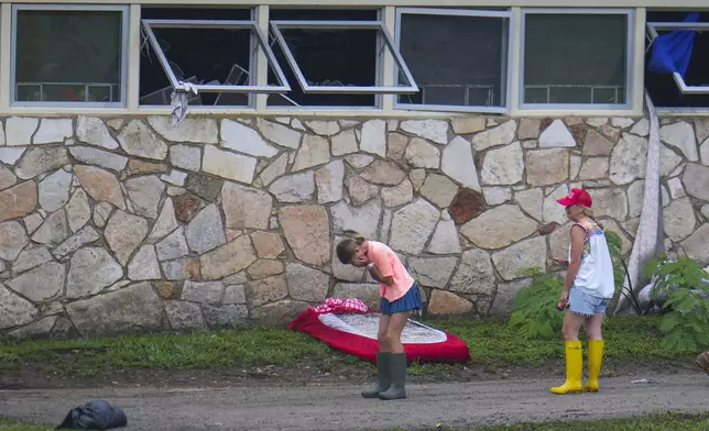 People react as they inspect an area outside sleeping quarters at Camp Mystic along the banks of the Guadalupe River after a flash flood swept through the area Sunday, July 6, 2025, in Hunt, Texas. (AP Photo/Julio Cortez)