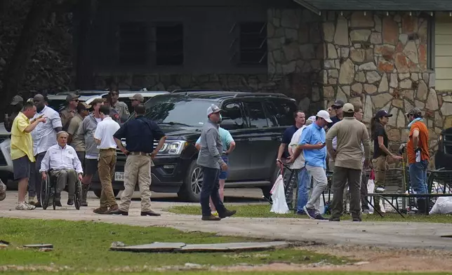 Texas Gov. Greg Abbot, second from front left, and U.S. Secretary of Homeland Security Kristi Noem, second from right, visit Camp Mystic along the banks of the Guadalupe River after a flash flood swept through the area Saturday, July 5, 2025, in Hunt, Texas. (AP Photo/Julio Cortez)
