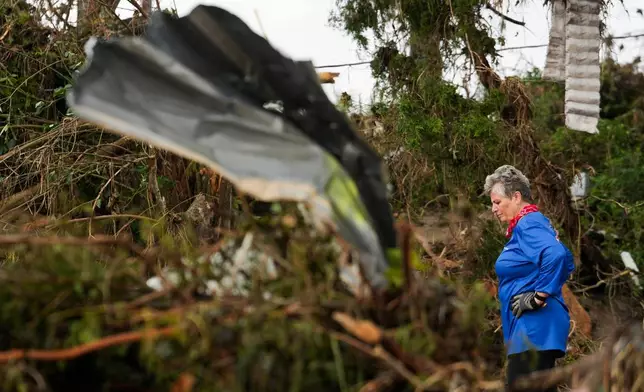 Myra Zunker takes a moment while searching for her missing niece and nephew along the Guadalupe River on Sunday, July 6, 2025, in Hunt, Texas. (Jason Fochtman/Houston Chronicle via AP)