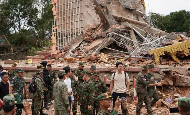 In this photo released by Agence Kampuchea Press (AKP), delegation of the military attaches and diplomats from 13 countries, including the United States and China, visit a damaged Buddhist pagoda in An Ses, a Cambodia–Thailand borders check point in Preah Vihear province, Cambodia, Wednesday, July 30, 2025, as observed the implementation of the Cambodia–Thailand ceasefire agreement. (AKP via AP)