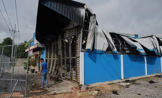 A man stands next to a damaged gas station in Phrong village, Oddar Meanchey province, Cambodia, Wednesday, July 30, 2025, after a ceasefire to end deadly border clashes was reached between Thailand and Cambodia. (AP Photo/Heng Sinith)