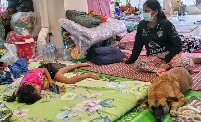 Thai residents who fled homes following the clashes between Thai and Cambodian soldiers, rest at an evacuation center in Surin province, Thailand, Wednesday, July 30, 2025. (AP Photo/Sakchai Lalit)