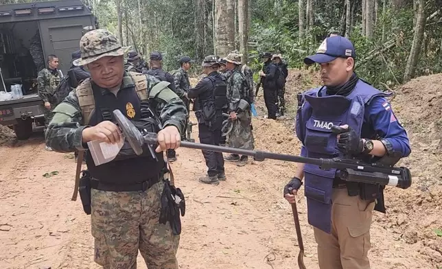 In this photo released by the Royal Thai Army, Thai soldiers inspect a border area on Sunday, July 20, 2025, in Ubon Ratchathani province, where the Royal Thai Army said two anti-personnel landmines were found. (Royal Thai Army via AP)