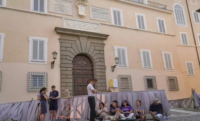 Faithful wait in front of the Pontifical palace in Castel Gandolfo where Pope Leo XIV is scheduled to deliver the Angelus prayer in his summer retreat, Sunday, July 13, 2025. (AP Photo/Gregorio Borgia)