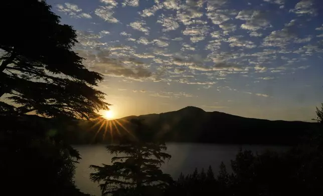 The sun raises over Castel Gandolfo where Pope Leo XIV is scheduled to deliver the Angelus prayer in his summer retreat, Sunday, July 13, 2025. (AP Photo/Gregorio Borgia)